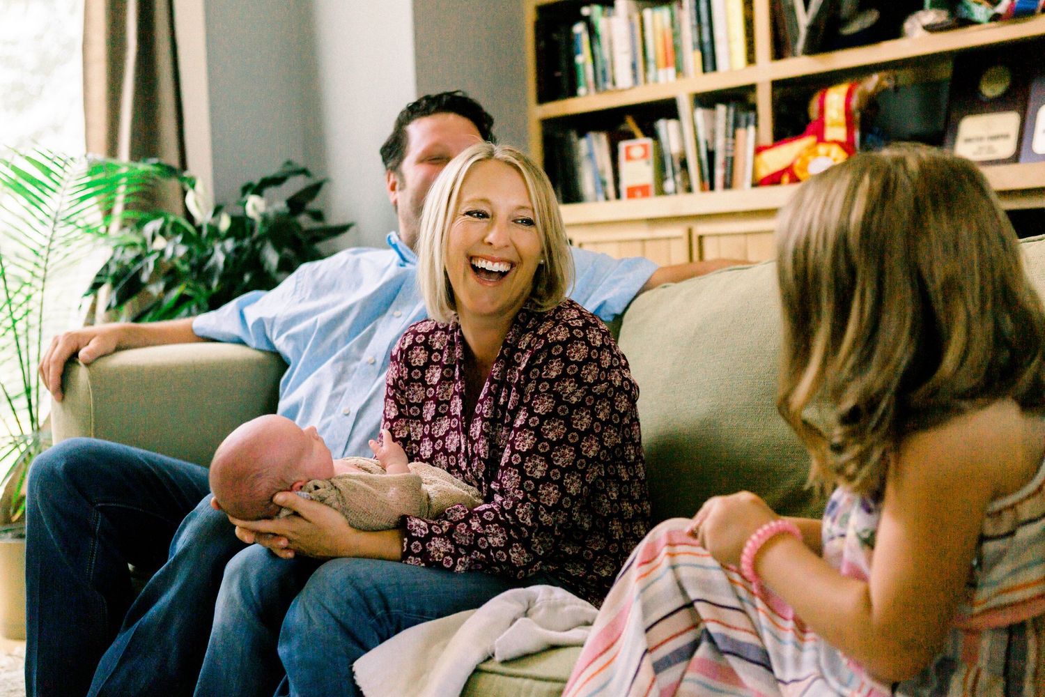 laughing family with newborn baby
