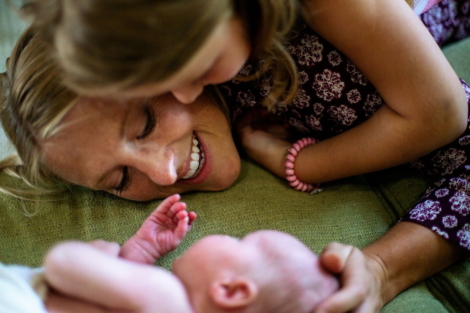 momma and daughter watching newborn son