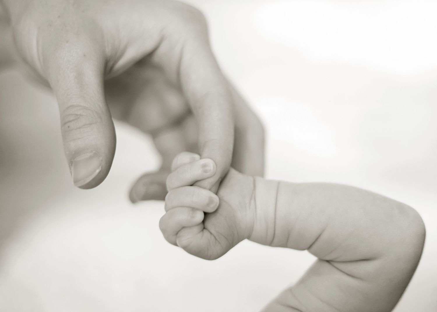 newborn holding hands with momma