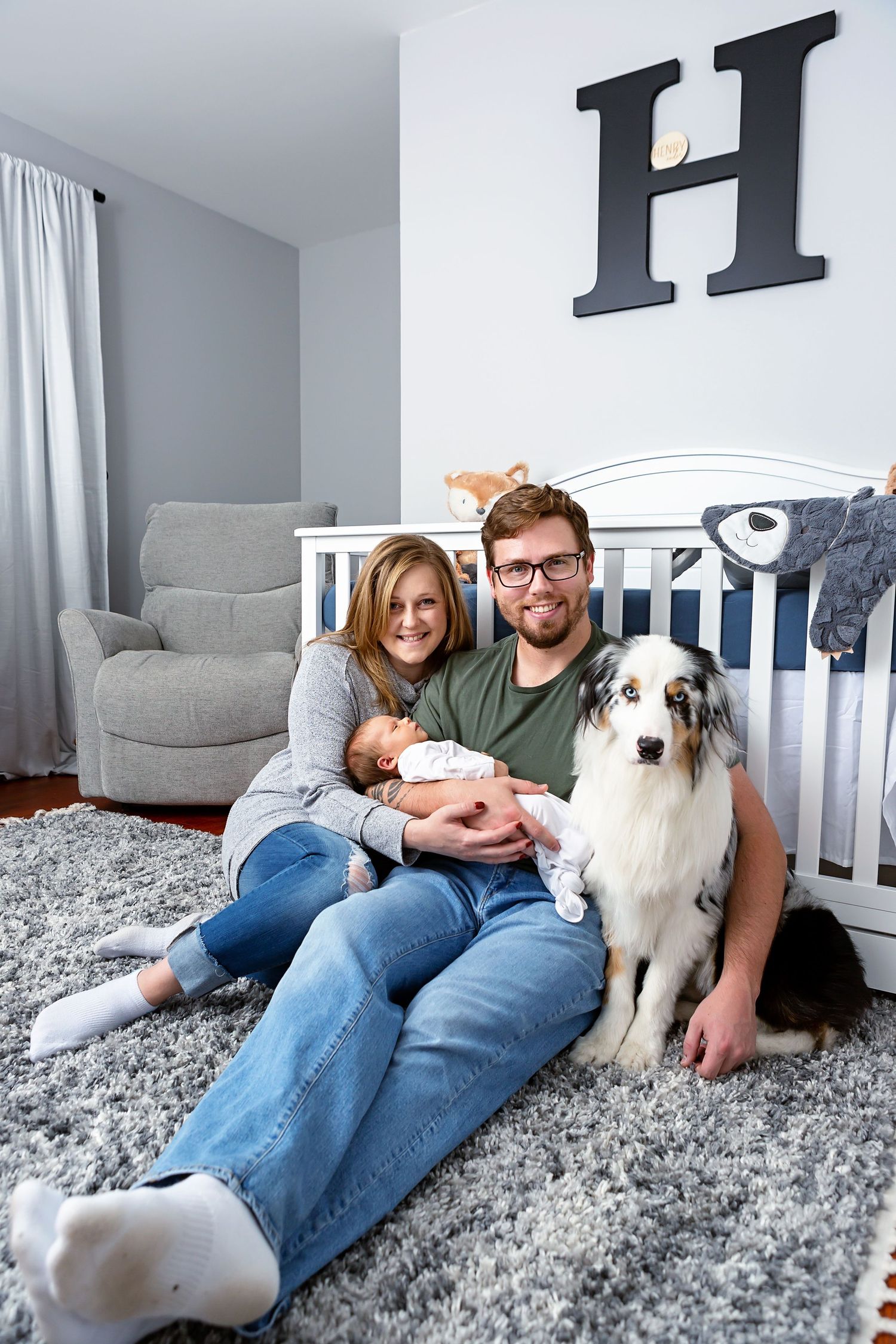 nursery family pic with H letter on the wall and aussie puppy