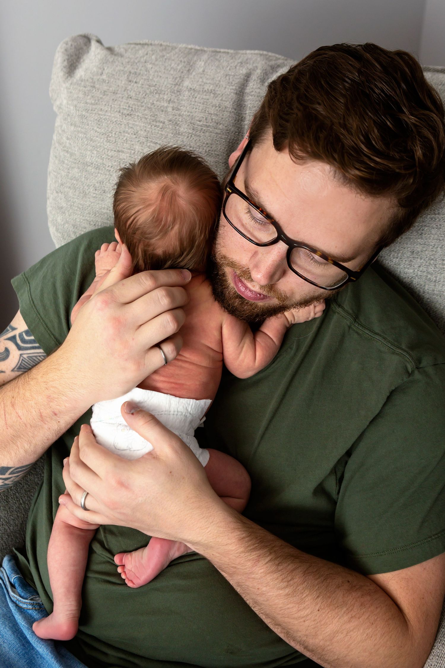 daddy holding his newborn son over his shoulder