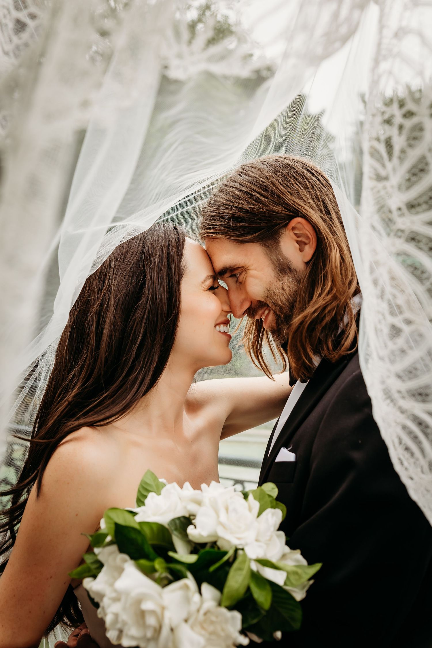A wedding couple facing each other under her veil at Saint James Court in Louisville, KY