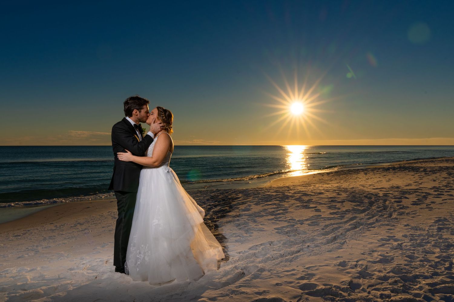 Sunset beach wedding photography with dramatic silhouette against the ocean.