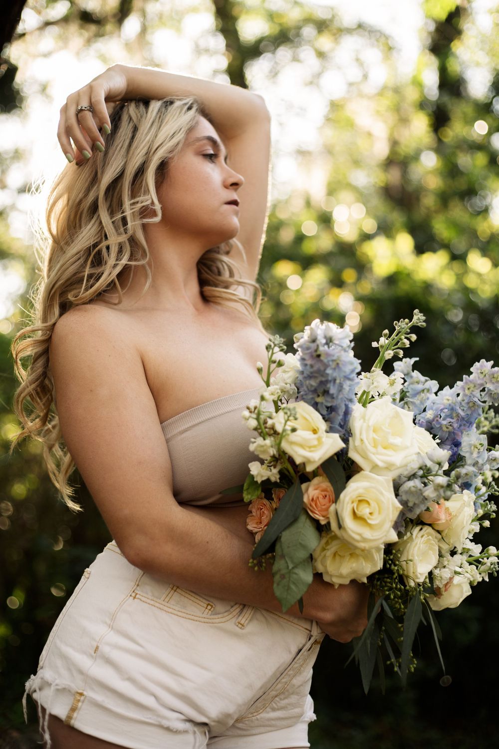 Elegant portrait with white roses and blue hydrangeas in a garden setting.