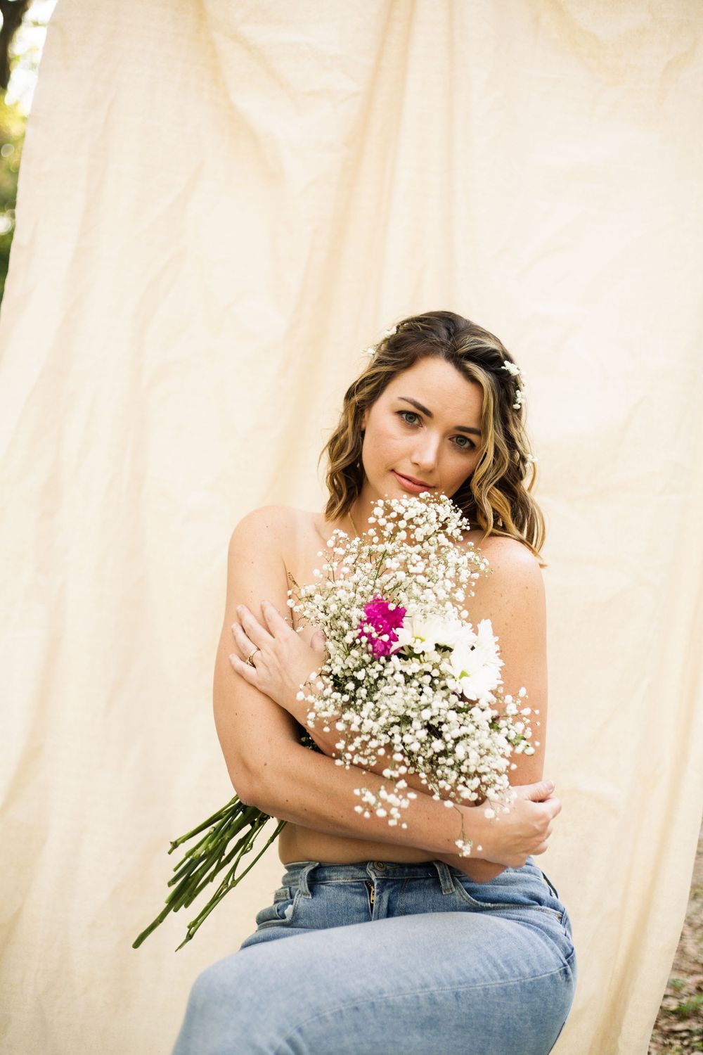 Elegant portrait with delicate white flowers and pink accent against ivory backdrop.