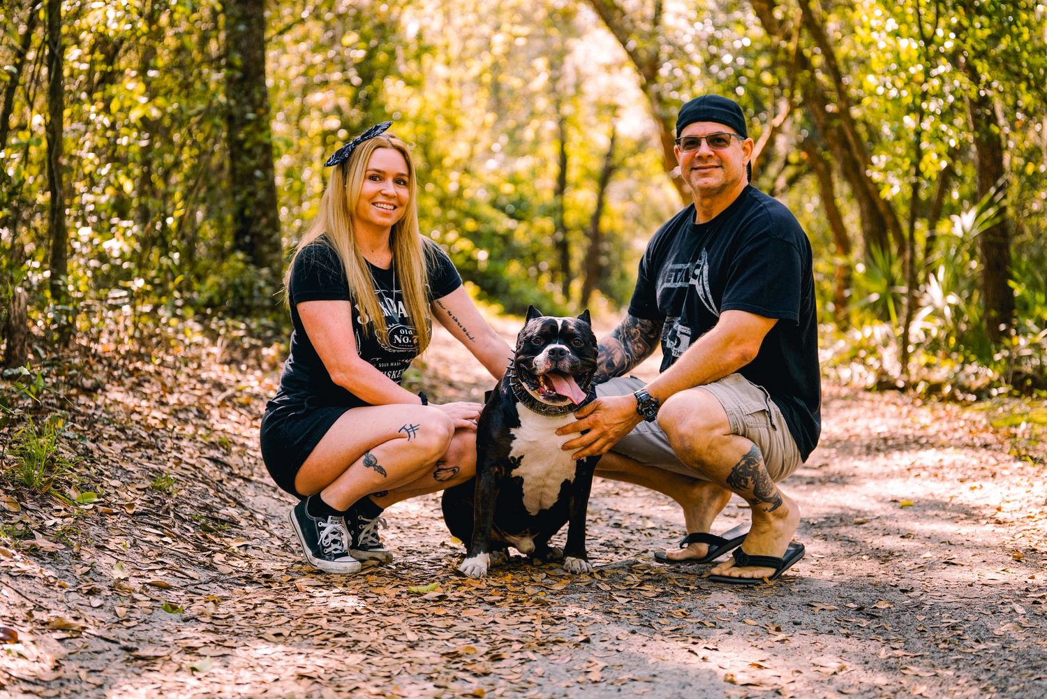 a couple and their dog posing on a walking trail with beautiful fall colors and lighting