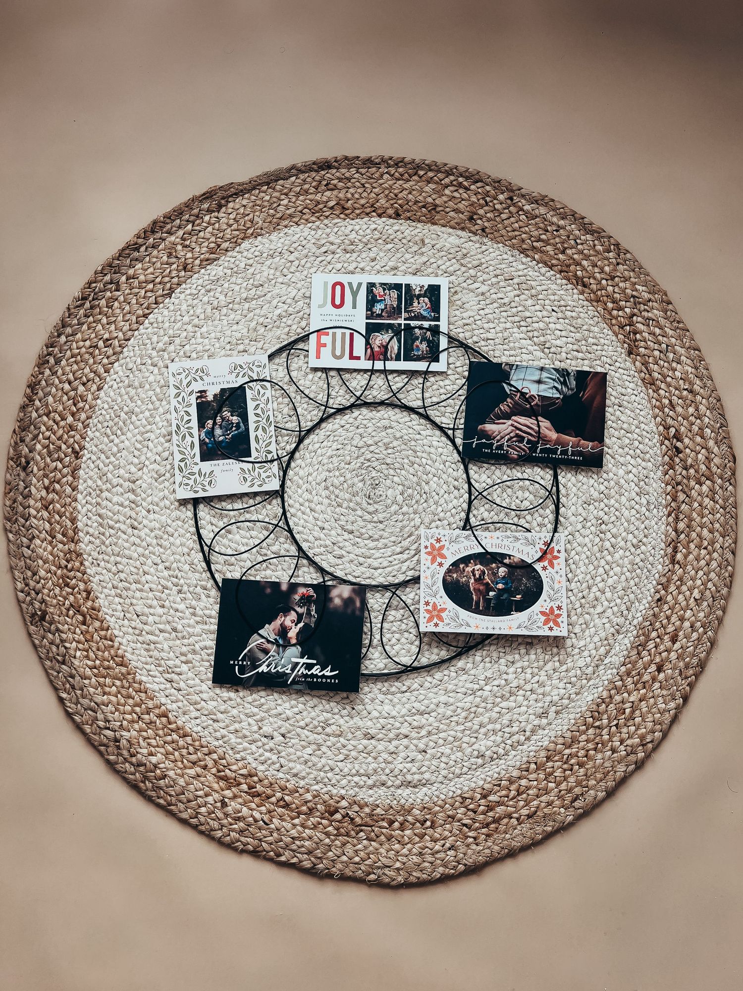 metal wreath on braided circle rug holding 5 family Christmas cards from Basic Invite