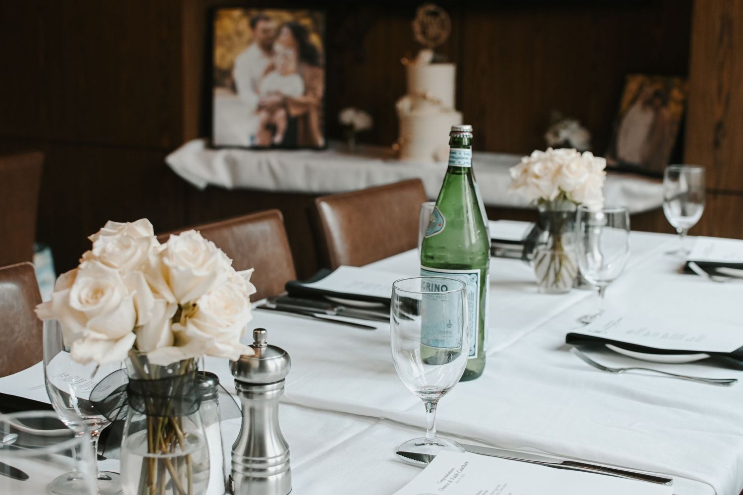 Formal wedding reception table settings with elegant white decor and glassware.