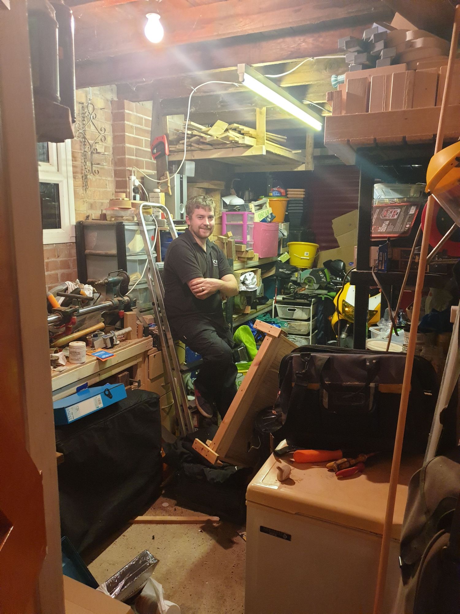 Cluttered workshop space with tools and equipment stored on shelves and workbenches.