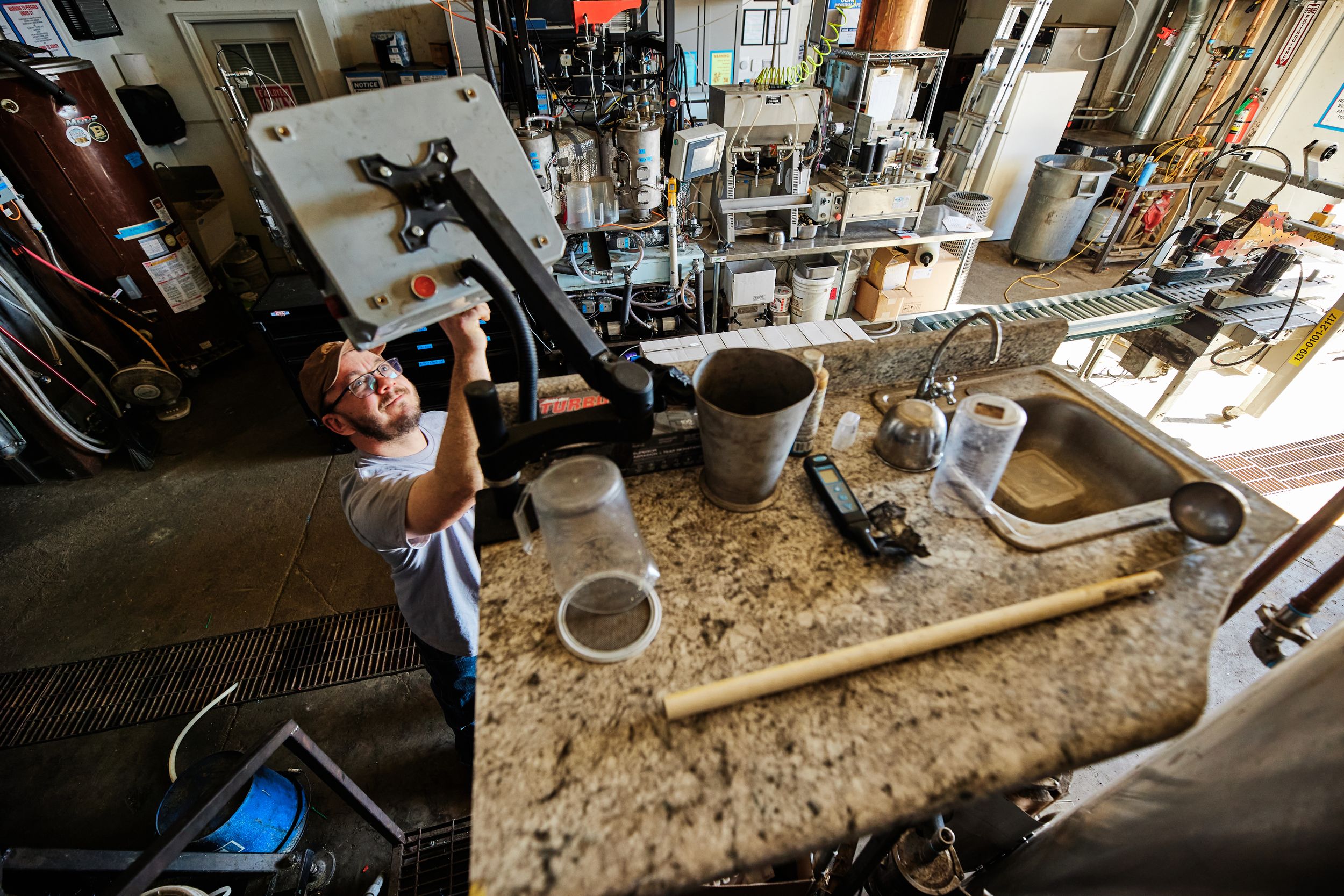 Distillery workspace with granite countertops and industrial equipment.