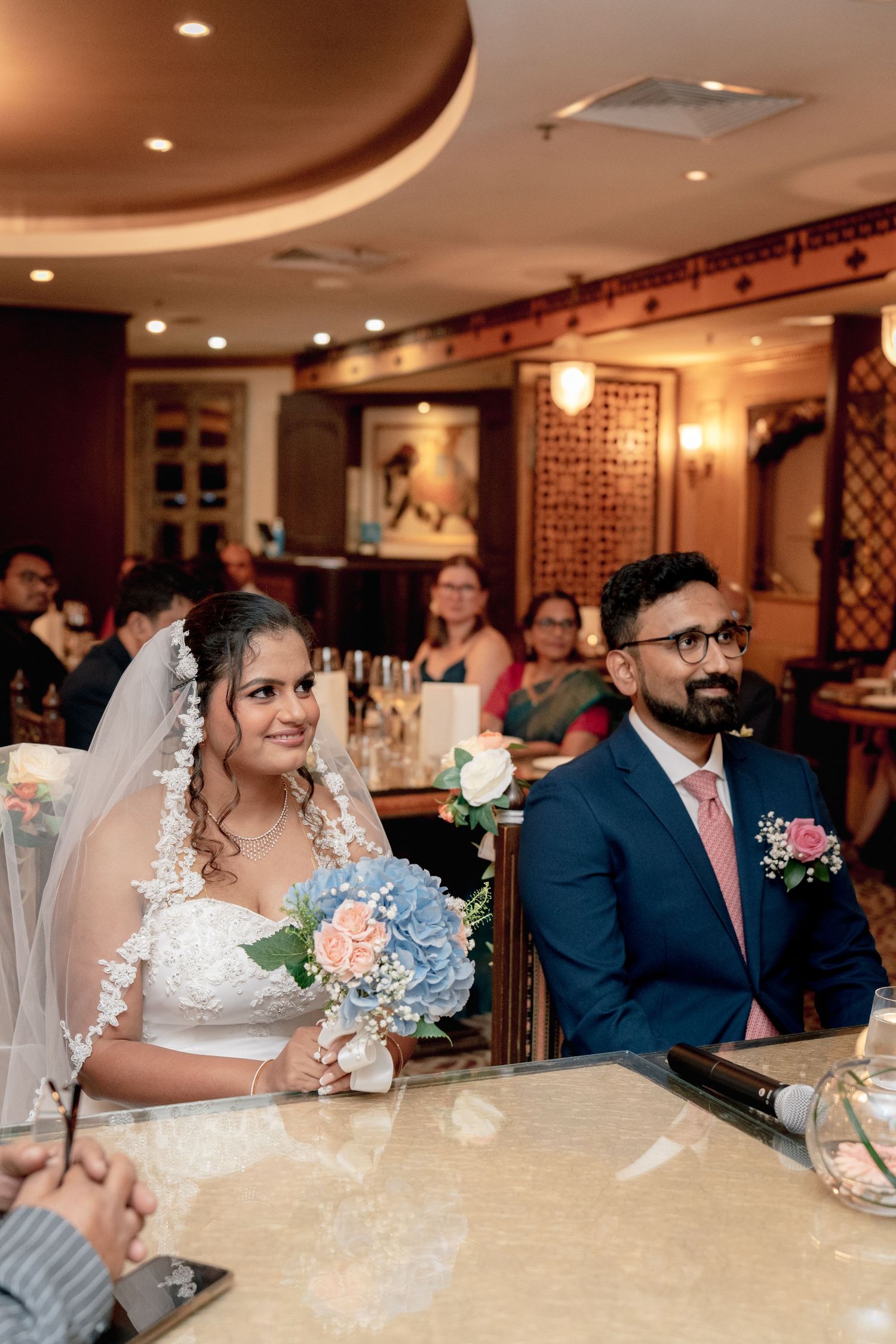Elegant wedding reception in a warmly lit restaurant with decorative wall details.