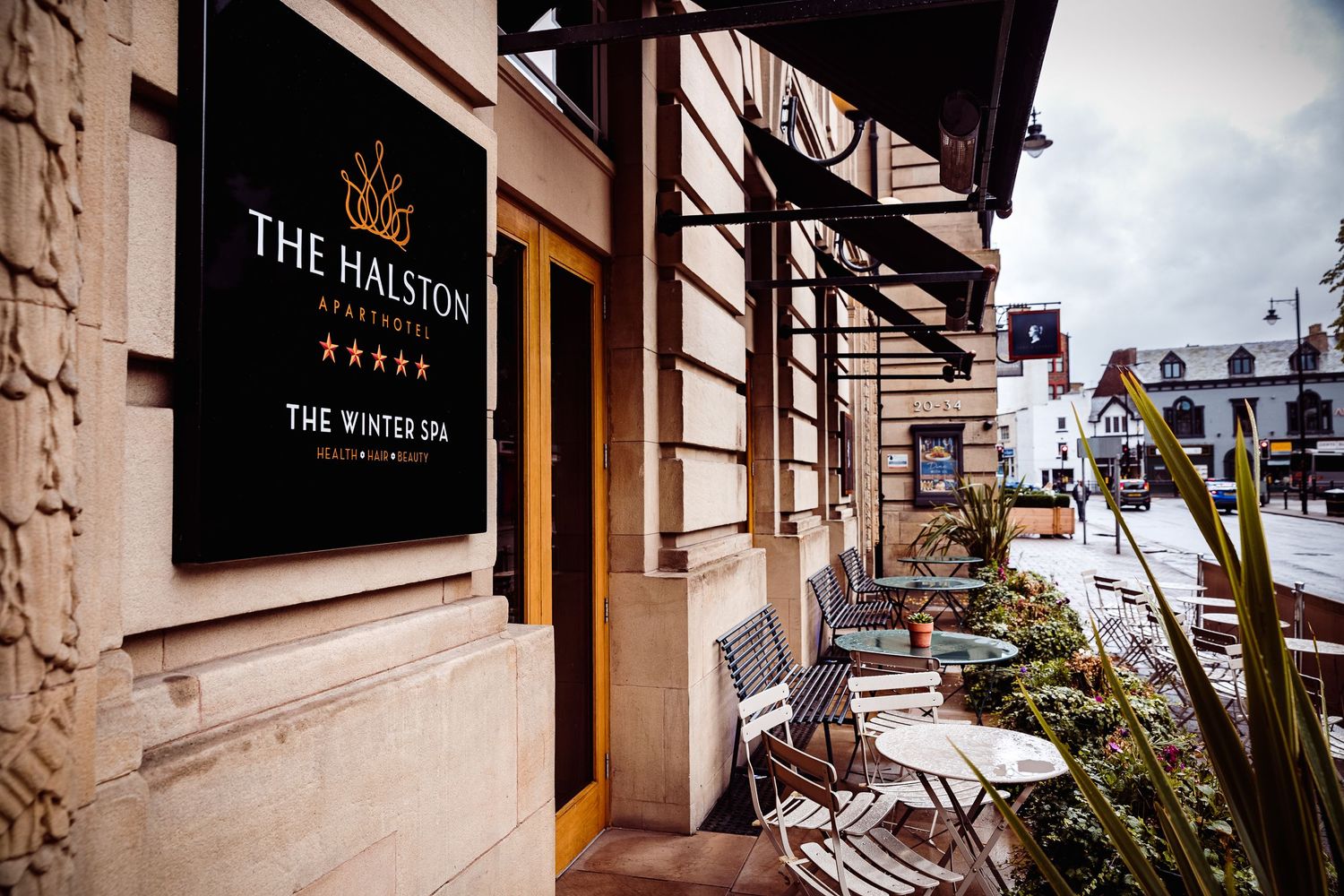 Exterior view of The Halston restaurant with outdoor seating and signage.