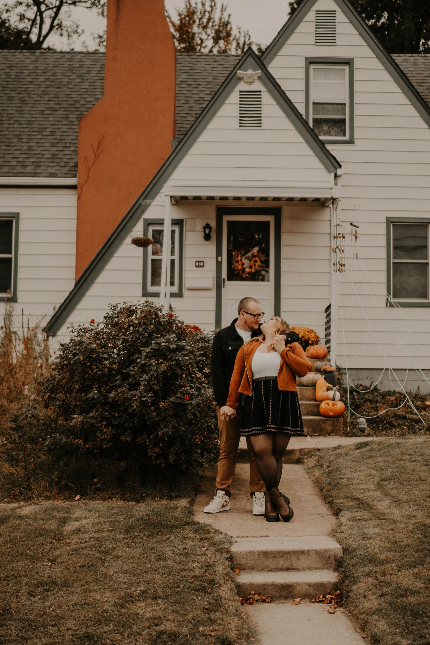 Fall themed front porch scene with pumpkins and seasonal decorations.