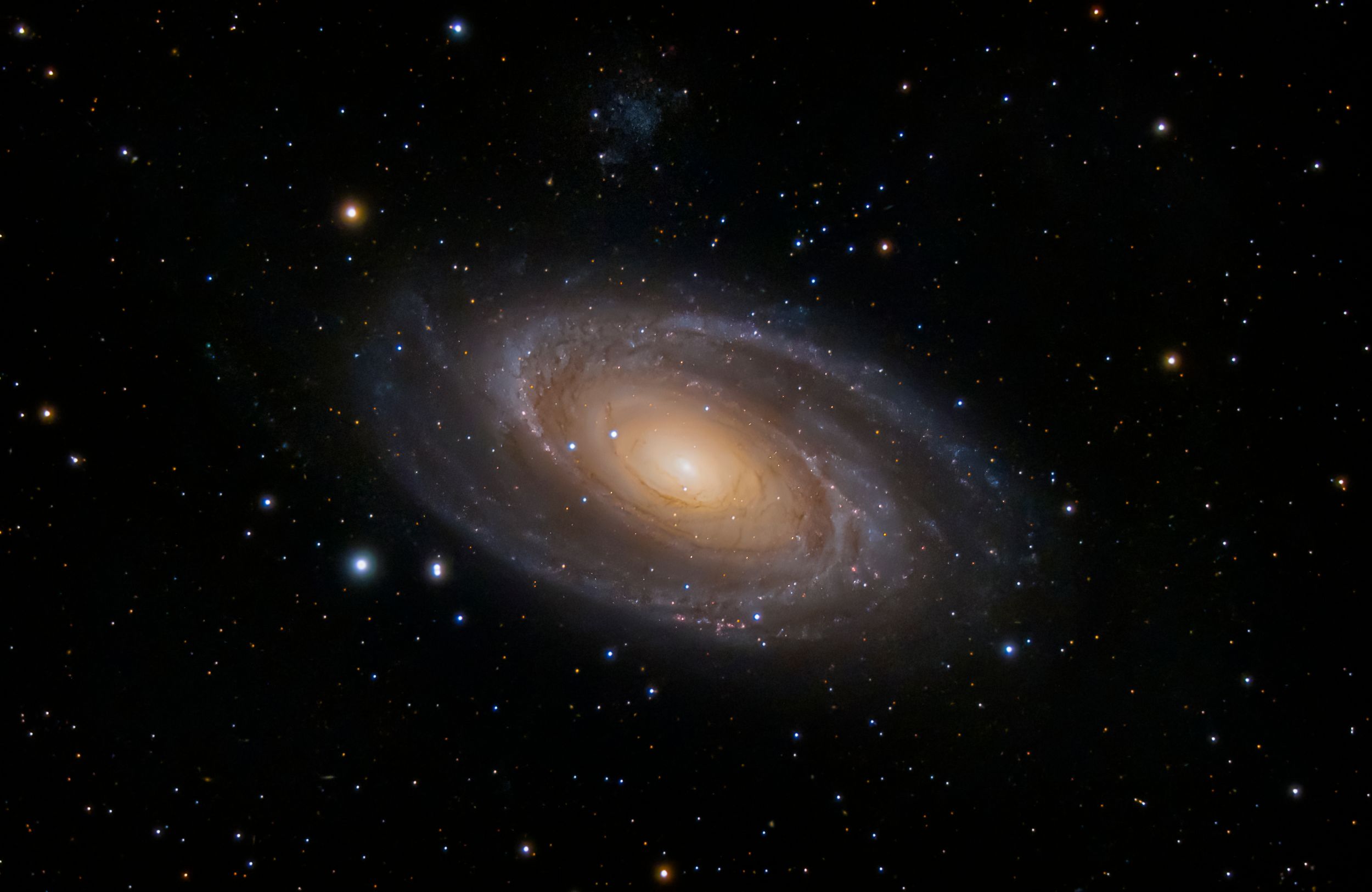 A spiral galaxy shines with a bright central core surrounded by sweeping golden arms in deep space.