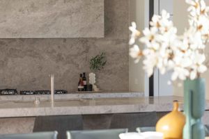 Elegant marble kitchen counter with soft natural lighting and yellow ceramic vase accent.