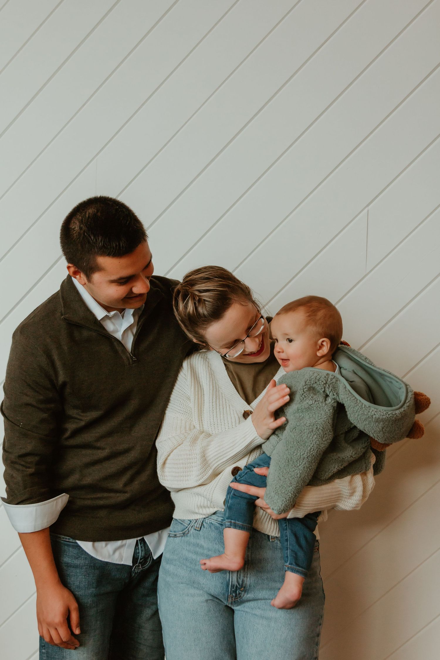 Happy family moment against white wooden wall background.