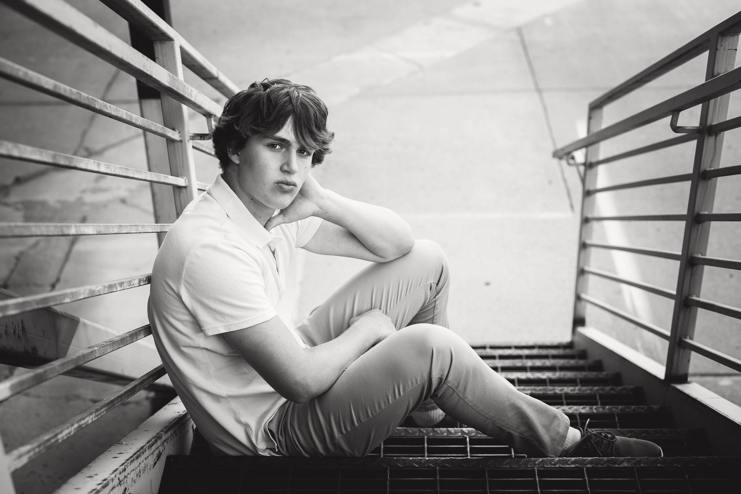 black and white image of a teenage boy relaxing on industrial steps