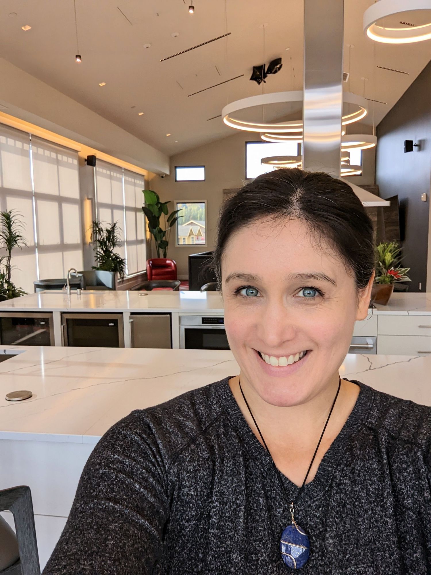 woman with dark hair blue eyes smiling for selfie while in kitchen for headshot networking photography event Woodinville