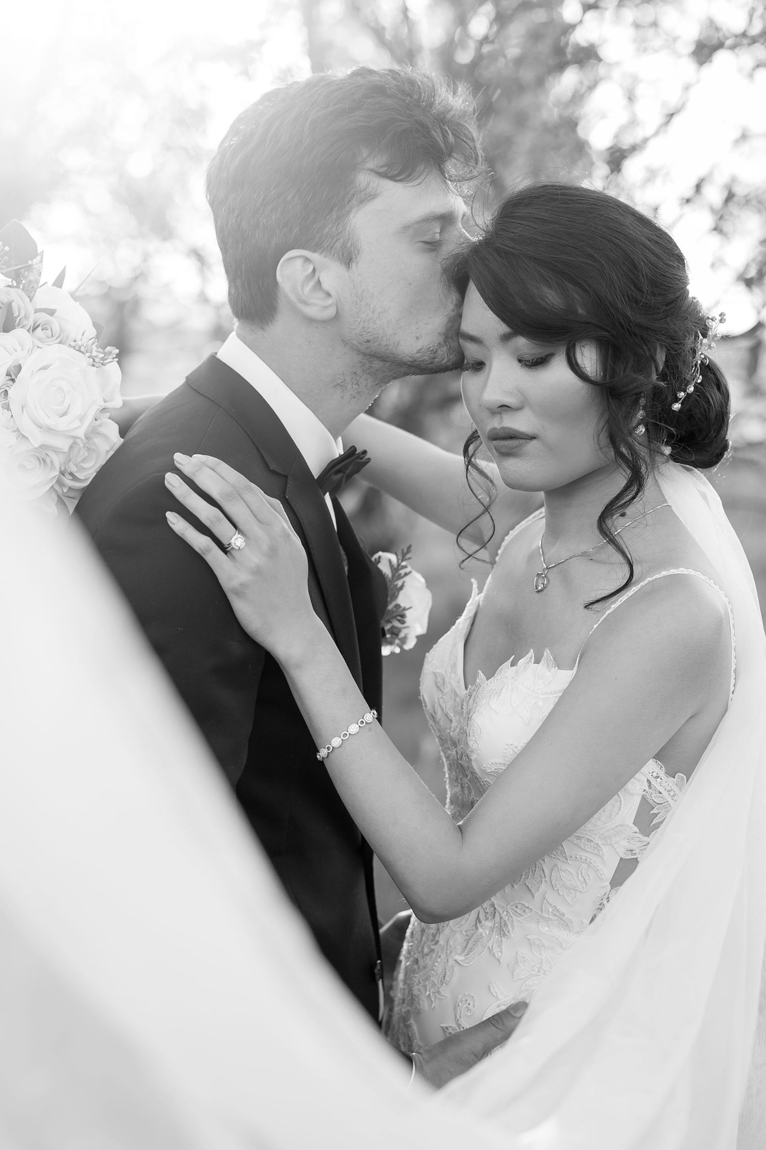 Bride and Groom kissing looking though her veil in the Orchard at De Bortoli Rutherglen captured in Black and White