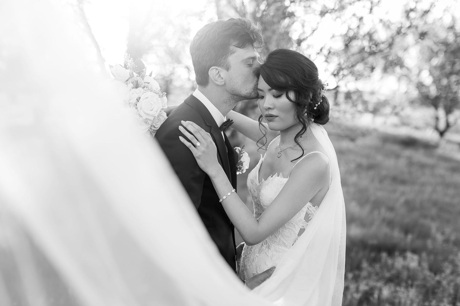 Bride and Groom kissing looking though her veil in the Orchard at De Bortoli Rutherglen captured in Black and White