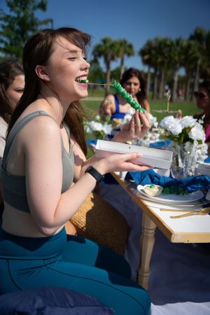 Guests seated at an outdoor dining table with blue tablecloth and white place settings.