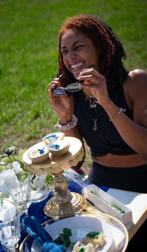 Laughter shared over an outdoor meal with decorative place settings and white flowers.