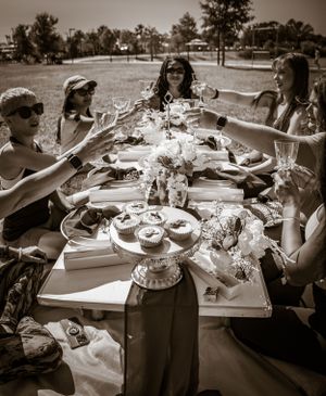 Black and white photo captures guests dining at an elegantly set outdoor table.