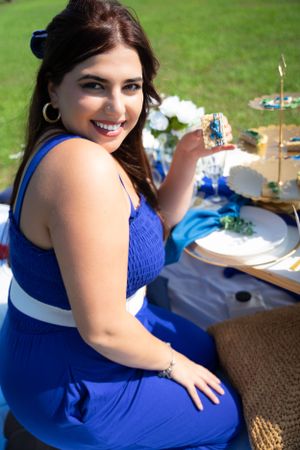Outdoor party setup with blue tablecloth and decorative place settings.