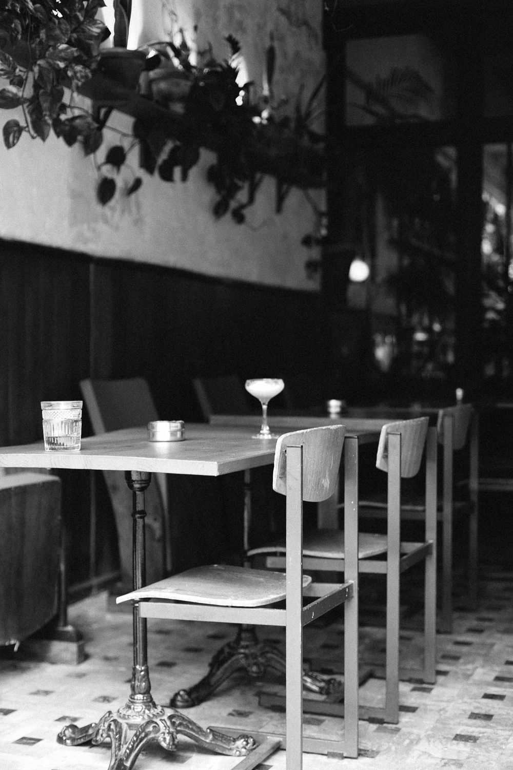 Black and white photo of empty restaurant table with vintage decor.