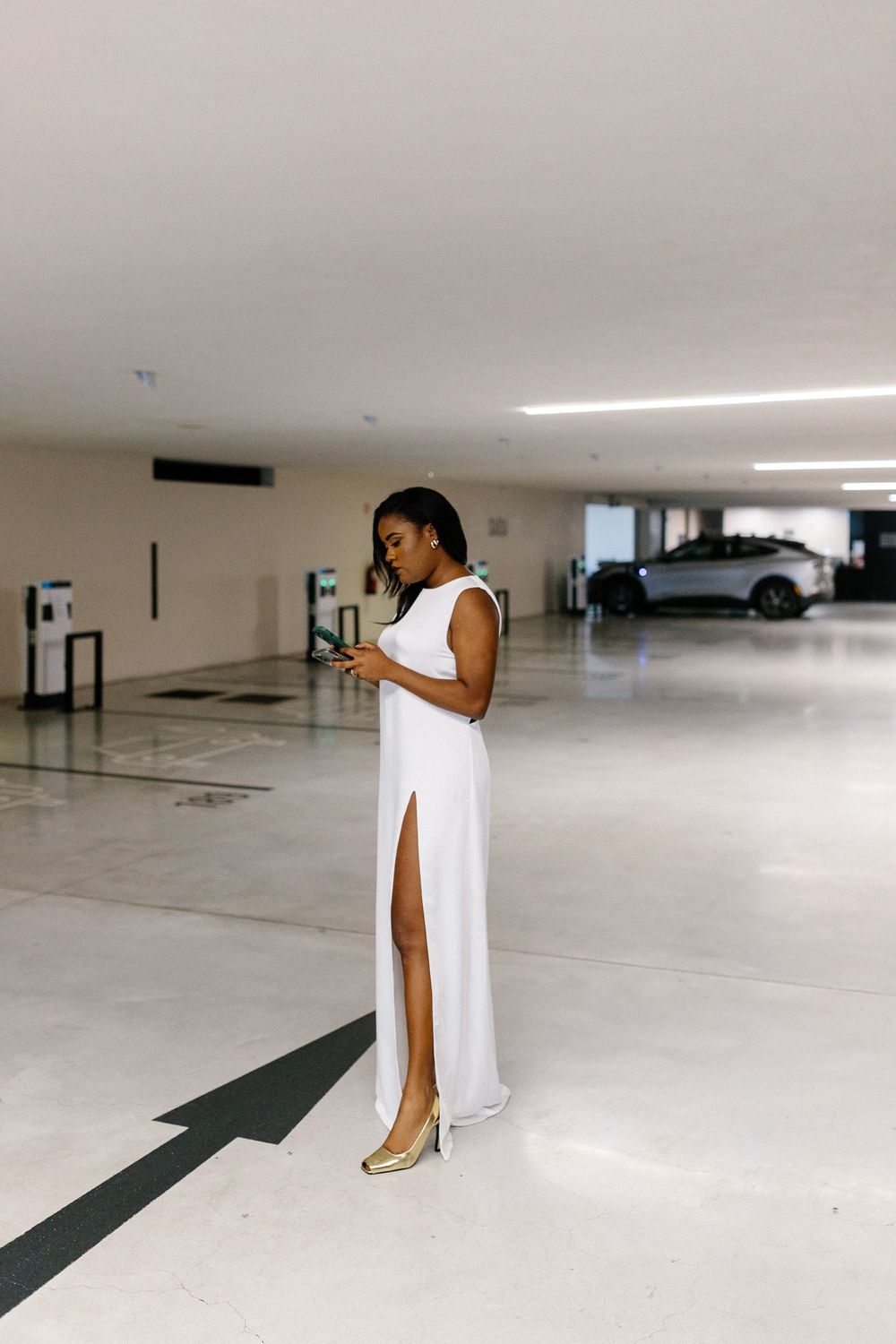 Two people walking in bright parking garage with SAIDA exit sign in black and white.