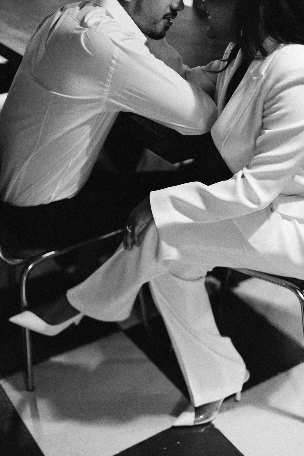 Artistic black and white photo of two people in contrasting outfits.