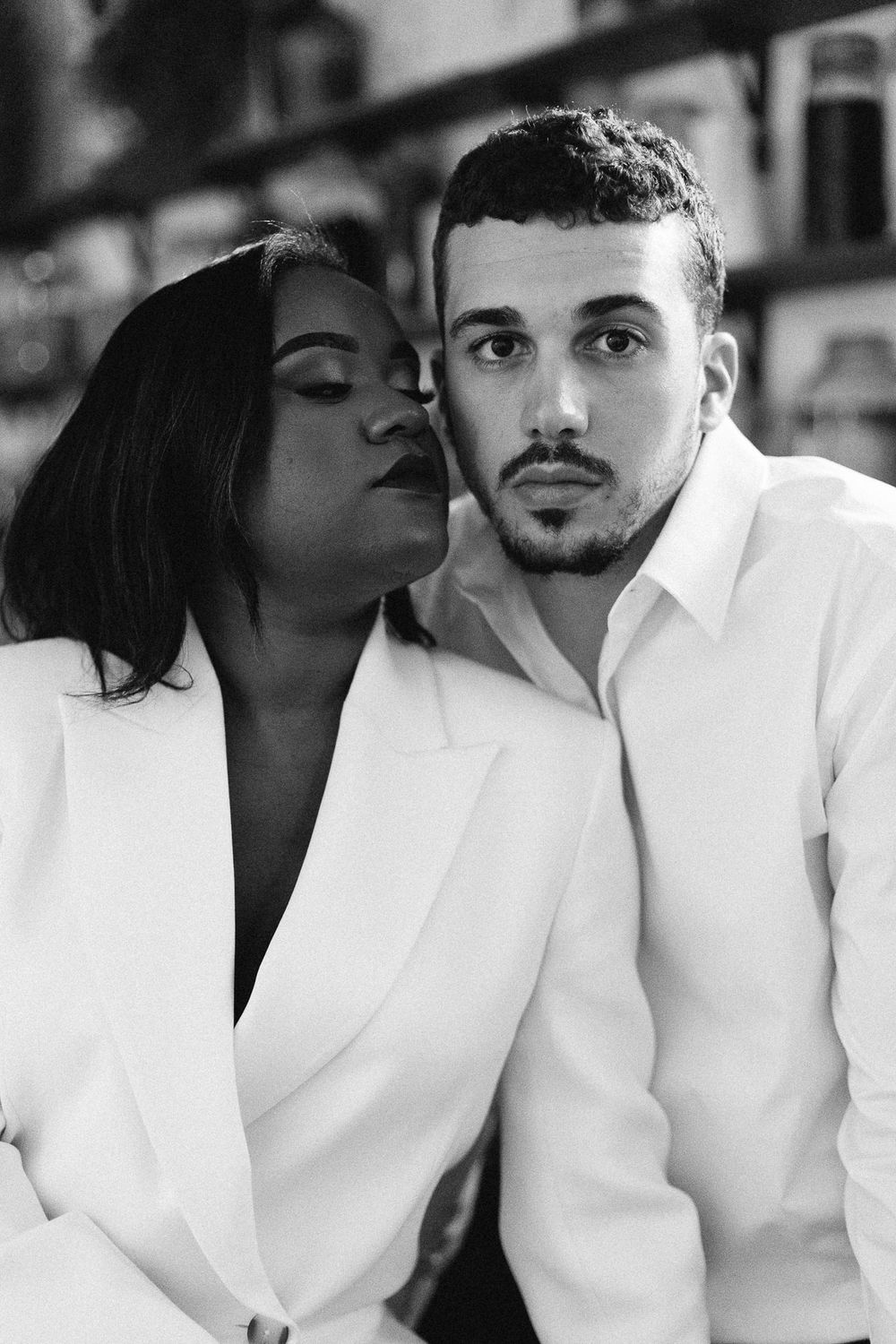 Intimate black and white portrait of couple in matching white outfits.