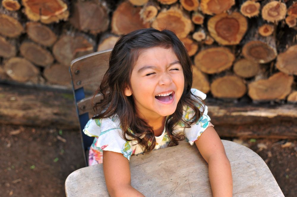 Girl laughing portrait at vintage school desk wood round wall