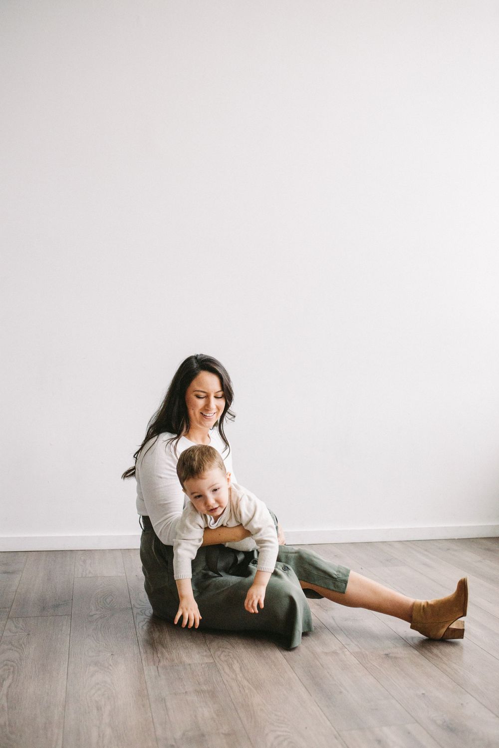 Candid moment of adult and child playing together on hardwood flooring.