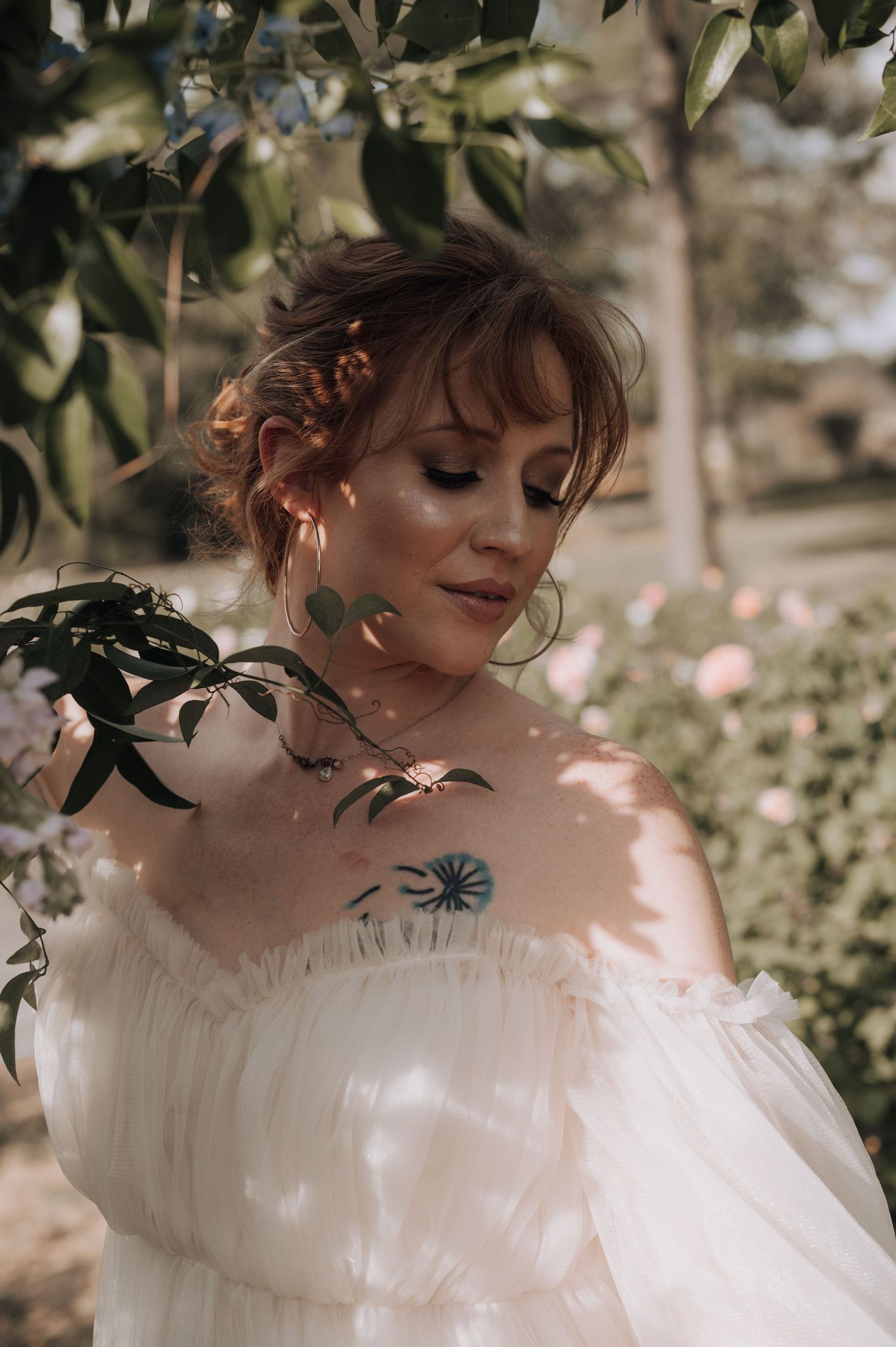 Soft, romantic bridal portrait with dappled sunlight through leaves.