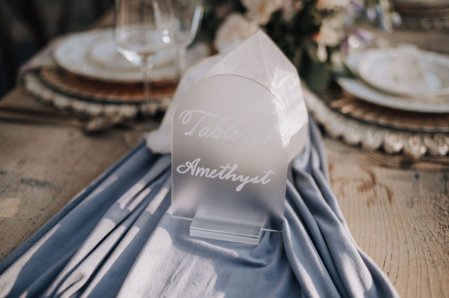 Navy blue table runner with white wedding name cards in elegant calligraphy.