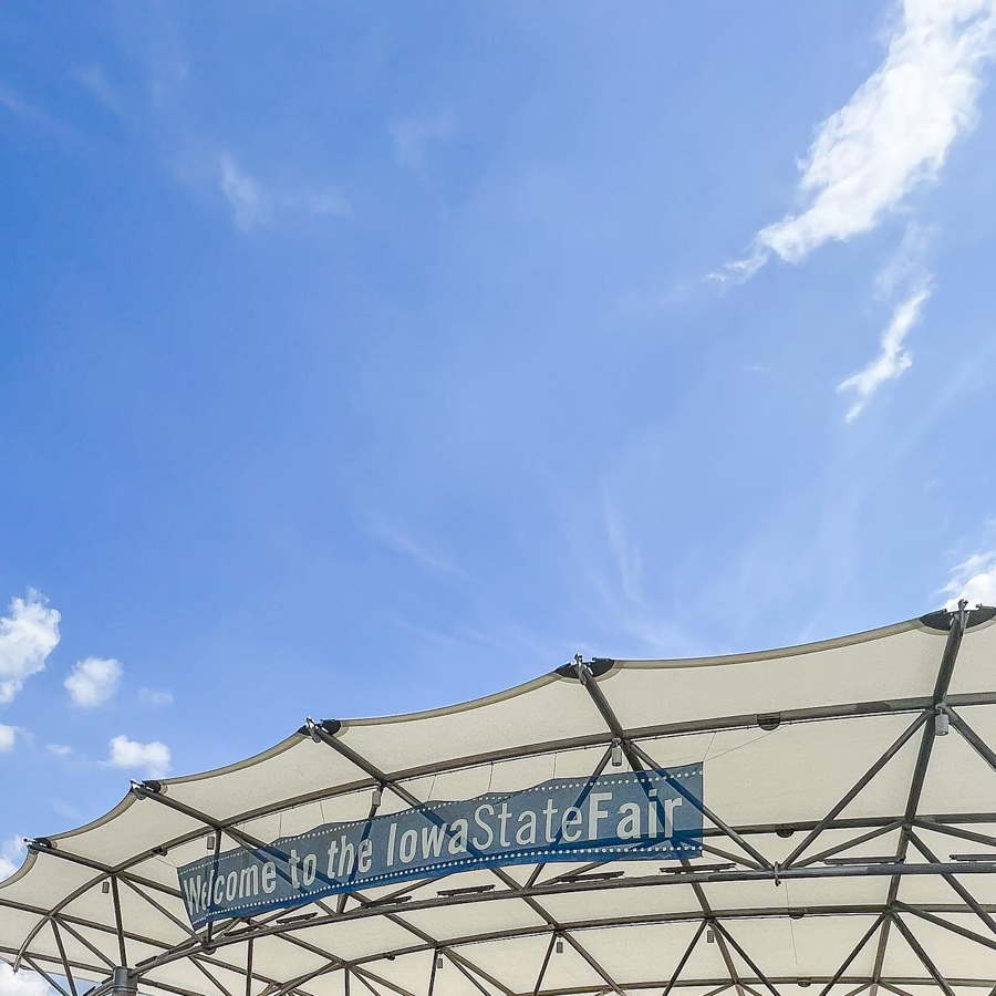 White canopy structures against a bright blue sky at an outdoor event.