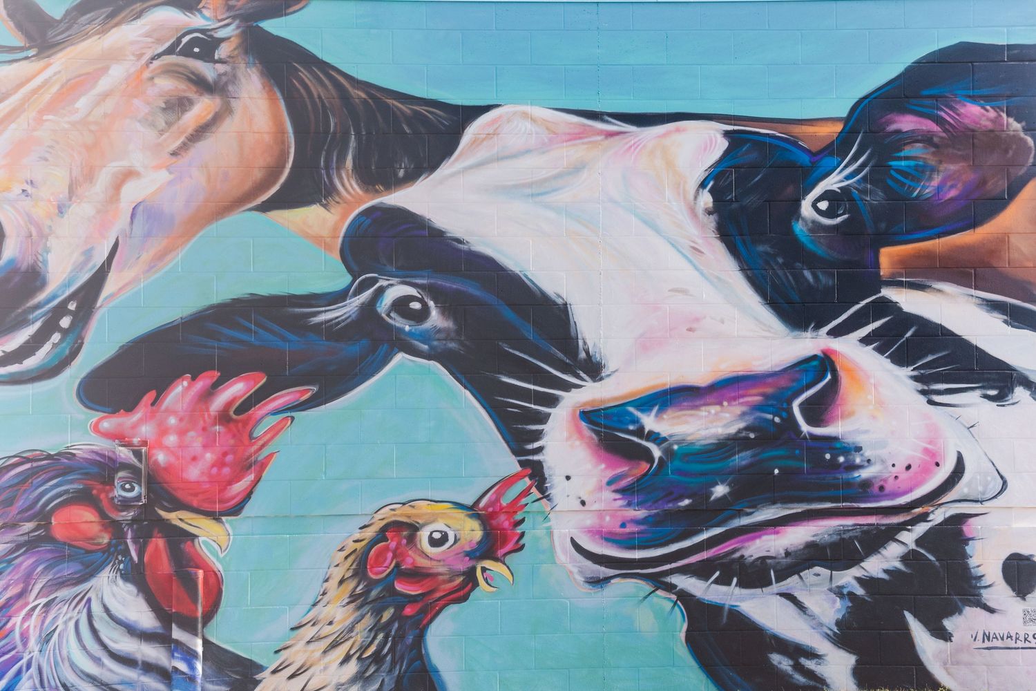 Colorful mural featuring farm animals including horses, cows, and roosters on turquoise background.