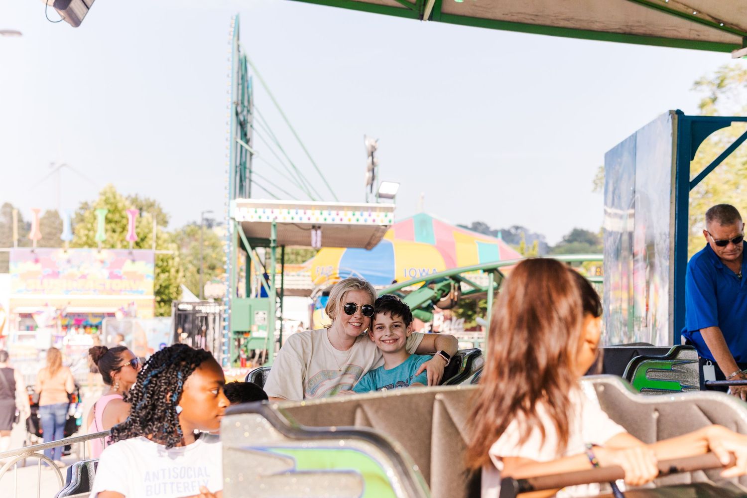 Passengers enjoying a ride on a carnival attraction with blurred fairground in background.