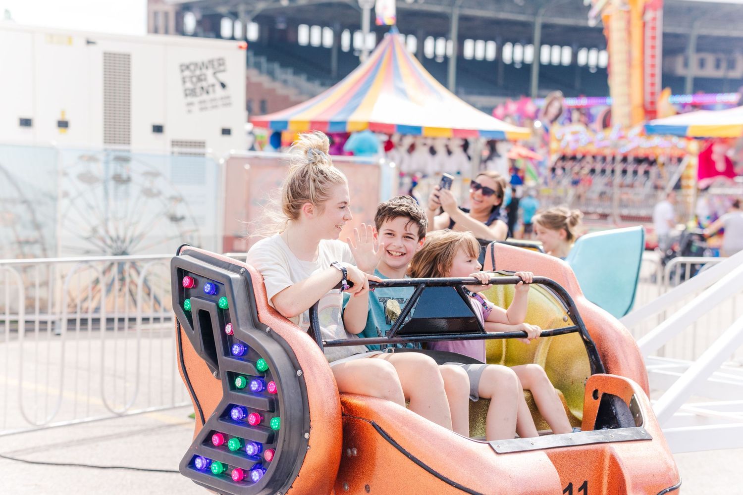 Colorful amusement park ride with orange seats spinning in motion at a carnival.