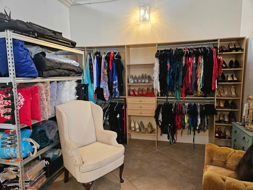 An organized wardrobe room with clothing racks and comfortable seating.