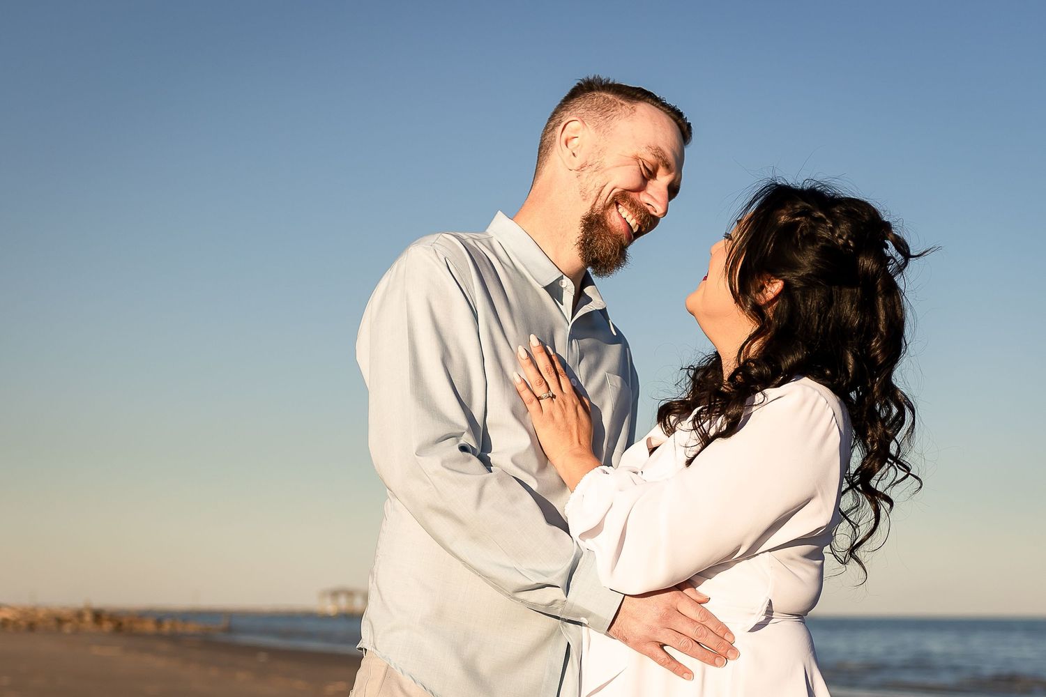 Couple sharing a joyful moment together at sunset on a beach.