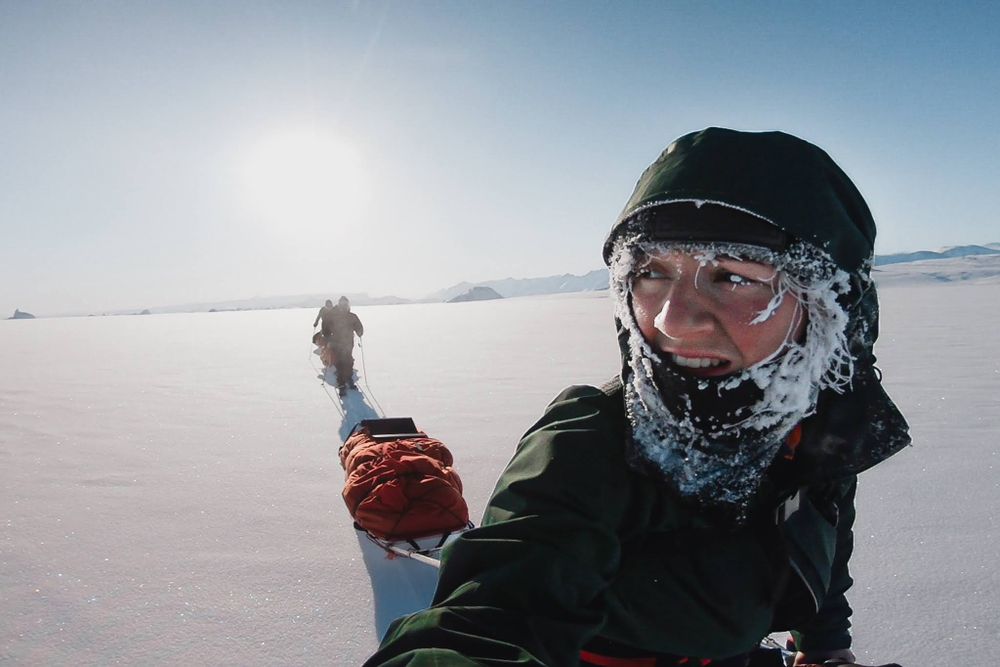 Charlotte Workman adventure filmmaker pulling a pulk across frozen sea ice in Greenland