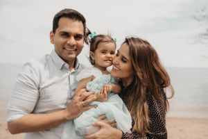 A family shares a tender moment together on a beach during a photo session.