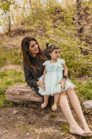 A peaceful scene of bonding on a rustic log surrounded by spring foliage.
