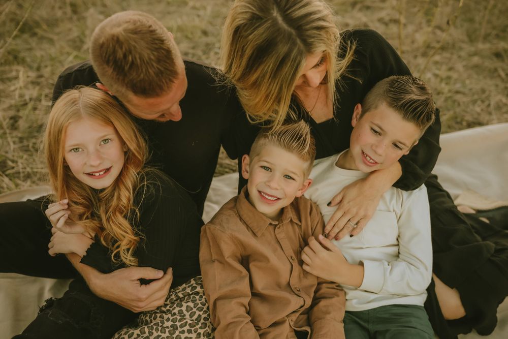 A sweet family bonding moment captured outdoors in warm golden tones during a casual photo session.