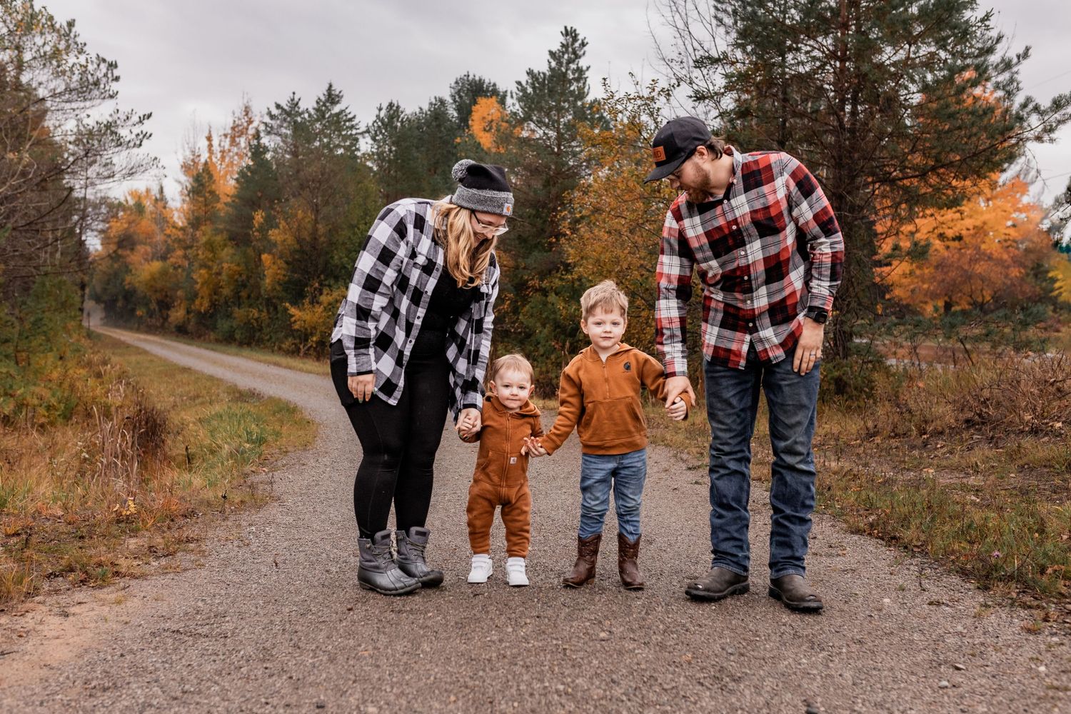A family walking together on a forest path surrounded by autumn foliage.
