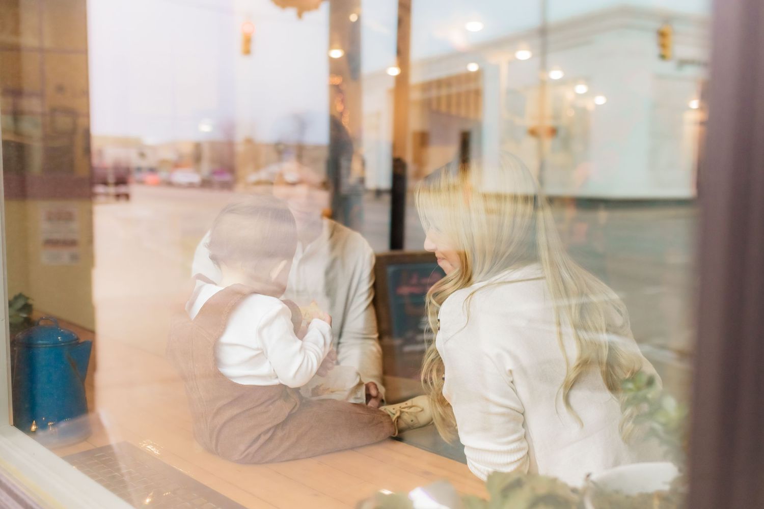 Blurry reflective window view of people sitting inside a cafe or restaurant.