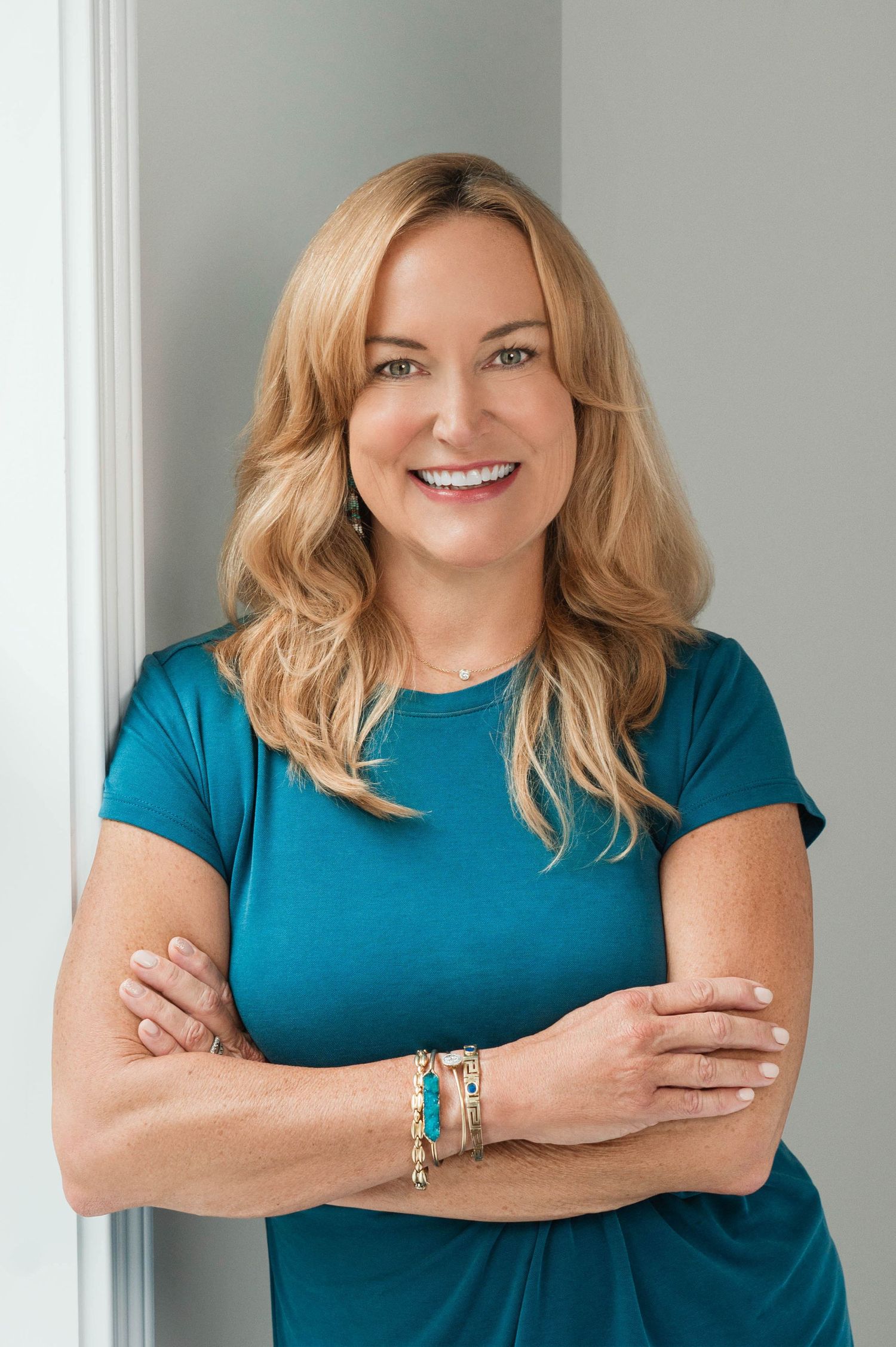 Business portraits in teal top showing confidence and warmth.