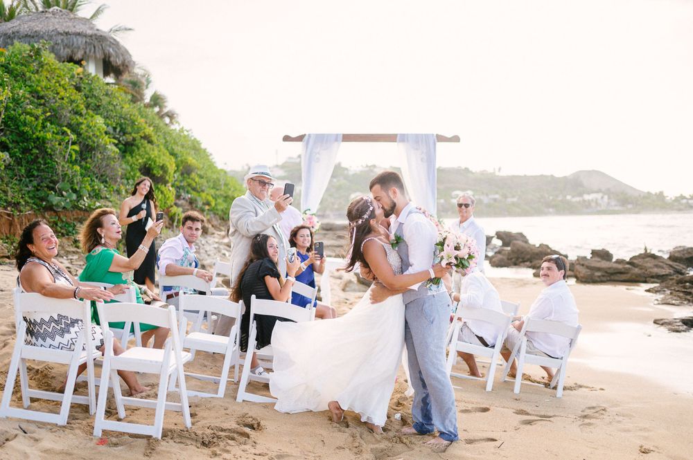 A beautiful beachside wedding ceremony with white chairs and tropical scenery.